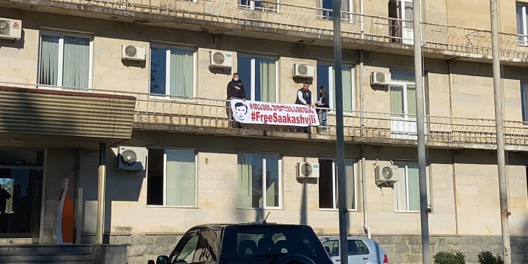 ამ წუთებში ოზურგეთის ადმინისტრაციულ შენობაზე ბანერი ”თავისუფლება მიშას” არის განთავსებული