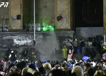 მომიტინგეები წყლის ჭავლის გაშვების შემდეგ წყალს სათლებში იღებენ და სპეცრაზმელებს უკან ასხამენ